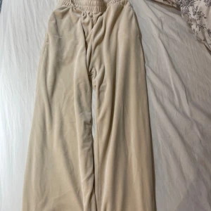 Beige mjukisbyxor från Bik Bok - Säljer ett par superbekväma beige mjukisbyxor från Bik Bok i storlek S. De har en elastisk midja och är perfekta för en avslappnad dag hemma eller en snabb tur till affären. Materialet är mjukt och skönt, vilket gör dem till ett måste i garderoben!