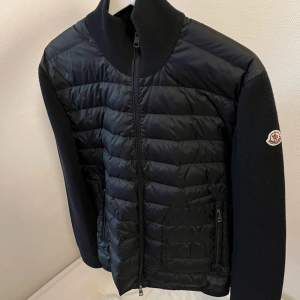 Säljer en snygg svart quiltad jacka från Moncler. Den har en dragkedja framtill och långa ärmar. Perfekt för höst och vår, med en stilren design som passar både till vardags och fest. Jackan är i mycket bra skick och redo för nya äventyr!