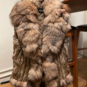 PÄLSVÄST - Inköpspris: 2700kr. ANVÄND 1 GÅNG! Superfin brun pälsväst i nyskick. Västen har 1 ficka på vardera sida & även 2 knäppen framtill så du kan stänga den om du är frusen, den är fluffig och varm, perfekt för höst och vinter. Den är gjord av mjukt pälsmaterial & passar perfekt för en stilren & rich look 💸 Den är ett måste om man vill vara snygg, elegant & samtidigt varm. Passar både storlek S & M