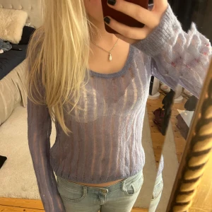 Ljuslila genomskinlig stickad tröja - Säljer en superfin ljuslila stickad tröja med ett transparent och randigt mönster. Den är perfekt för lager-på-lager och har en skön, loose passform. Tröjan är långärmad och passar perfekt till både vardag och fest. Perfekt för vår och sommar!