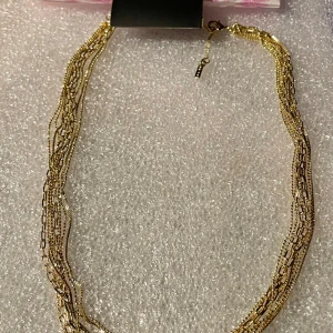 *NY*Lily - Guldpläterad halskedja från Pilgrim, Julklappstips!  - Snyggt guldhalsband från Pilgrim med flera tunna kedjor som ger en elegant look. Perfekt för att lyfta vilken outfit som helst, oavsett om det är till vardags eller fest. Halsbandet har en justerbar kedja för att passa olika längder. Kommer i asken. 
