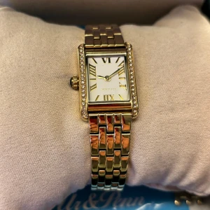 Ivy N Rox Bliss - Guldig klockan från Ur och Penn, märket Ivy n Rox. Klockan är i rostfritt stål. Storlek 19x28mm. Jag har tagit av två länkar och den sitter lösare på mig då jag ville ha den rörlig. Jag har tyvärr inte armbandet som va i setet kvar.🤍