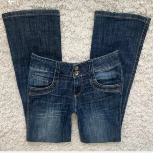 Mörkblå bootcut jeans - Säljer ett par snygga mörkblå bootcut jeans i bra skick. De är lågmidjade och har en klassisk femficksdesign med dubbla knappar i midjan. Perfekta för både vardag och fest!💕 köpta på Plick men passade tyvärr inte 
