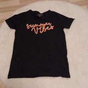 Säljer en svart t-shirt från XOXO friends i storlek 134/140. Den har ett coolt 'Summer Vibes' tryck i orange och vitt på framsidan. Perfekt för sommardagar! Gjord i 100% bomull för en skön känsla. 🖤