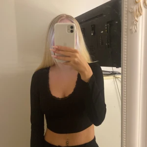 Svart croppad långärmad topp - Snygg svart croppad topp med långa ärmar. Perfekt för en utekväll eller att matcha med ett par höga jeans. Toppen har en enkel och stilren design som passar till det mesta.