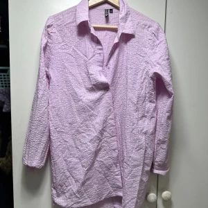 Ljuslila skjorta från pieces - Säljer en ljuslila skjorta från pieces i storlek M. Skjortan har ett diskret prickigt mönster och är långärmad. Perfekt för både vardag och festliga tillfällen. Den är i mycket bra skick och gjord av ett bekvämt bomullsmaterial. Passar perfekt till vår och sommar!