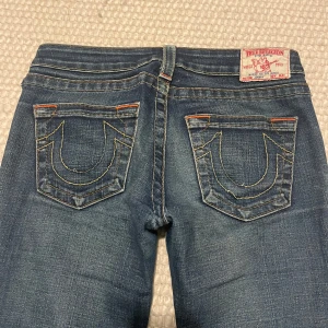 True Religion jeans - Säljer dessa populära true religion jeansen. Dom är lågmidjade och utsvängda. Enda defekten är att dom är slitna där nere. Skriv för fler frågor!🤍