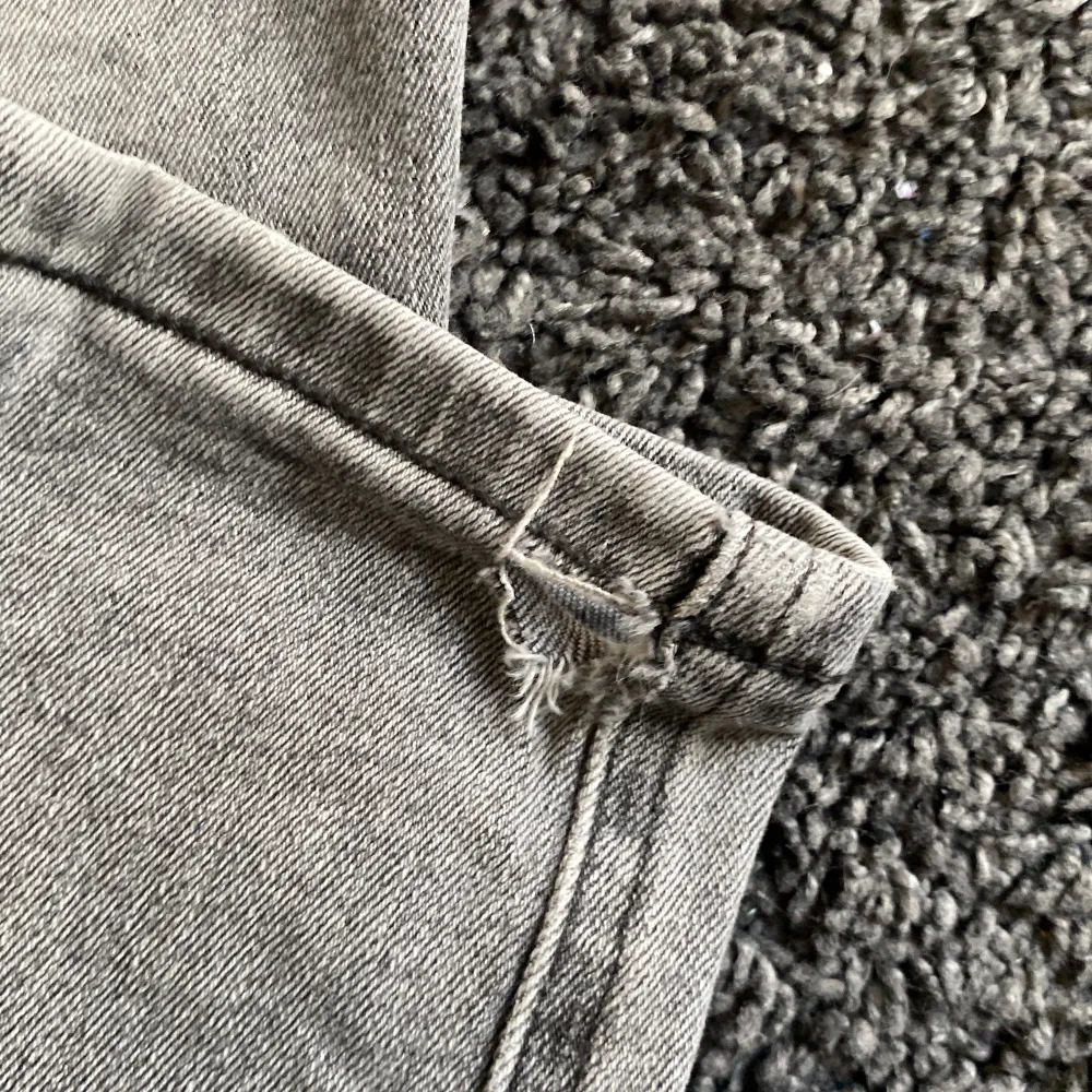 Säljer ett par grå jeans i bra skick med ett håll vid högra smalbenet kolla bild . De har en klassisk femficksdesign och är perfekta för både vardag och fest. Jeansen har en slim passform och är tillverkade i ett slitstarkt material. Perfekta för höst och vår!. Jeans & Byxor.