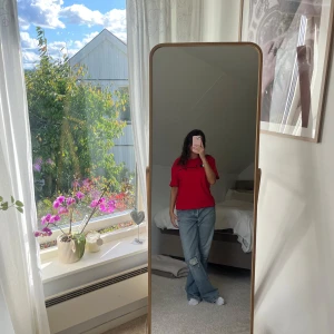 Röd t-shirt från Champion - Säljer en snygg röd t-shirt från Champion i bomull. Den har en stor logga på bröstet och en mindre på ärmen. Passar s/m