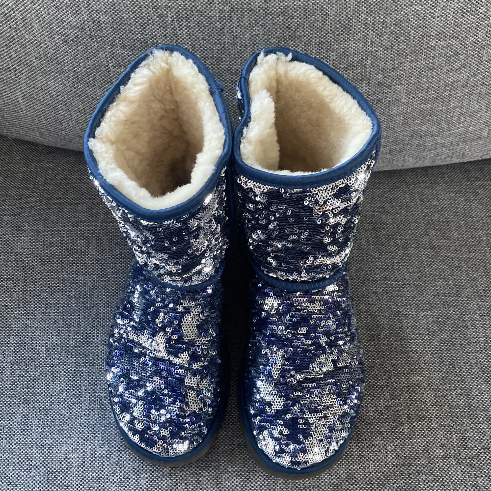 Säljer ett par supercoola UGG boots i blått med glittriga paljetter över hela ytan. De är fodrade med mjukt och varmt foder, perfekt för kalla dagar. Sulan är robust och ger bra grepp. Dessa boots är både snygga och bekväma, idealiska för vinterns alla äventyr! ✨. Kengät.