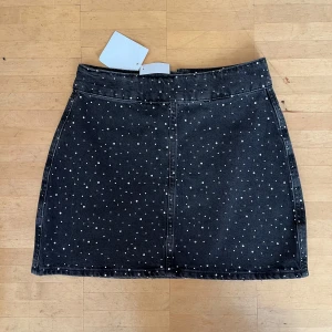 Glittrig jeanskjol - Jättefin jeanskjol med rhinestones, aldrig använd och prislapp kvar. Slutsåld på hemsidan. Nypris 699.