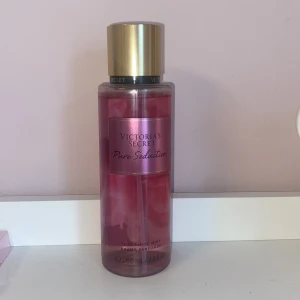 Victoria's Secret Pure Seduction Body Mist - Säljer en Victoria's Secret Pure Seduction body mist. Flaskan är rosa med en guldig kork och rymmer 250 ml. Doften är en mix av saftig plommon och krossad fresia, perfekt för en kväll ute. En fräsch och förförisk doft som håller hela natten. Jag köpte den i somras på en flygplats för 25€ och har bara sprutat 2 gånger då doften inte passade mig. Man kan diskutera priset! 