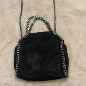 Stella McCartney väska  - Jätte snygg svart Stella McCartney väska. Är i jätte bra skick har använts några fåtals gånger. Skriv till mig om ni vill ha mer information om väskan eller fler bilder! Pris kan diskuteras