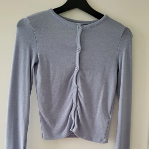 Gina tricot tröja - Ljusblå tunn tröja från gina tricot 2023. Endast använd 1 gång då den va för liten. Knappar hela vägen ner.   Storlek: XS  Skickas inslagen i silkespapper i vattentätt paket.   Skicka pm för fler bilder. 