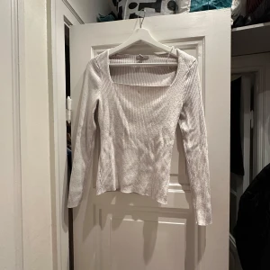 Vit ribbad tröja - Säljer en stilren vit ribbad tröja med lång ärm och fyrkantig halsringning. Tröjan är  bra skick men skrynklig pga legat i påse på vinden. Superbekväm och lätt att matcha med olika outfits!🤍