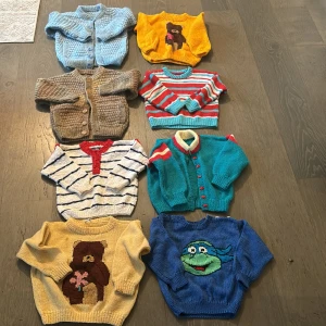 Färgglada stickade barntröjor - Säljer ett gäng supergulliga stickade barntröjor i olika färger och mönster. Perfekta för höst och vinter! Det finns en blå kofta med knappar, en gul tröja med en nalle, en randig tröja i rött och turkost, och flera andra unika designer. Alla är långärmade och i bra skick. Perfekt för att hålla de små varma och stiliga!