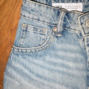 Blå jeansshorts från Zara - Säljer ett par snygga blå jeansshorts från Zara i storlek XS. De är högmidjade med en cool fransig kant och klassisk femficksdesign. Perfekta för sommardagar. Bilder finns privat🫶