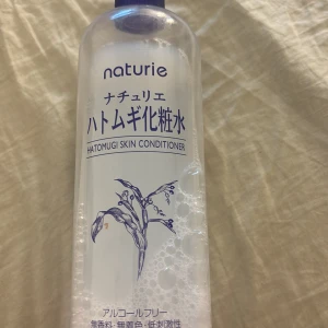 Naturie Hatomugi Skin Conditioner - Säljer en stor flaska av Naturie Hatomugi Skin Conditioner. Den är alkoholfri och perfekt för att återfukta huden. Flaskan är genomskinlig med blå text och har en enkel design. Perfekt för daglig användning för att hålla huden mjuk och fräsch. 1/3 kvar.