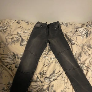 Svarta jeans med slitningar - Säljer ett par svarta jeans i bra skick. De har en cool slitningseffekt på framsidan och är i en straight passform. Perfekta för både vardag och fest! 🖤