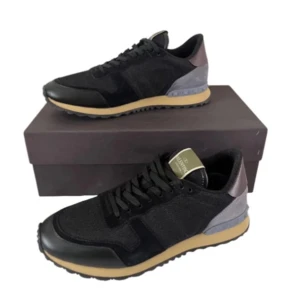 Valentino Rockrunner sneakers - Snygga Valentino Rockrunner sneakers i svart och grått med coola detaljer. De har en kombination av mocka och skinn, vilket ger en lyxig känsla. Perfekta för både vardag och fest! Skorna har en bekväm passform och snygg snörning framtill. Kvitto finns!!! Original låda medföljer ej men dustbags gör!!!