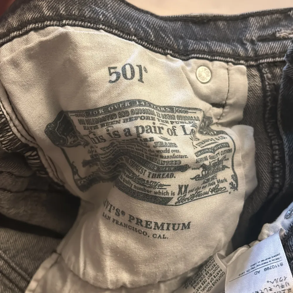 Säljer ett par klassiska grå Levis 501 jeans i bra skick. De har en straight passform och är tillverkade i slitstarkt denim. Perfekta för både vardag och fest! 🖤. Jeans & Byxor.