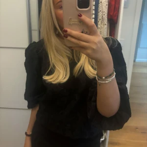 Svart blus med puffärmar - Säljer en elegant svart blus med puffiga ärmar. Perfekt för både vardag och fest! Materialet har en fin struktur som ger en lyxig känsla. Passar bra till både jeans och kjol. 🖤