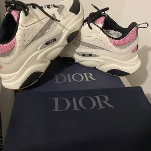 Säljer ett par snygga Dior sneakers i vitt och rosa. De har en chunky sula och svarta detaljer som ger en cool look. Perfekta för att lyfta vilken outfit som helst! Skorna är i nyskick och kommer med förpackning. Pris går diskutera snabb affär!!