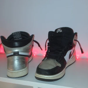 Nike Air high Jordan retro high silver toe  - Säljer ett par Nike Air Jordans i svart och silver. Skorna har en klassisk hög modell med snörning och Nike-logga på sidan. De är i ganska dåligt skick men det går och fixa, de är perfekta nu till vintern.