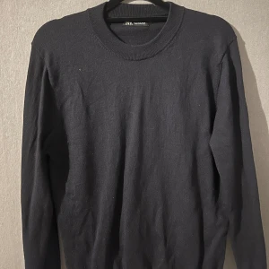 Svart tröja från Zara - Säljer en stilren svart tröja från Zara i mycket bra skick. Den är långärmad och perfekt för både höst och vinter. Tröjan har en normal passform och är gjord i ett mjukt material som känns skönt mot huden. Perfekt basplagg för garderoben!