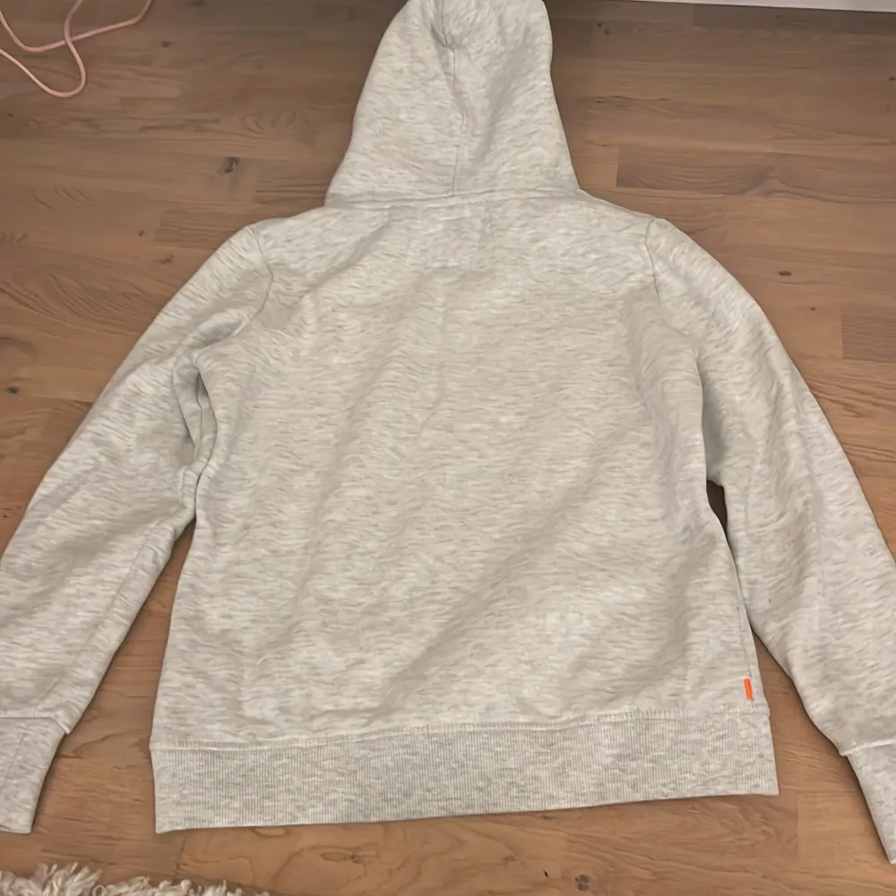 Säljer en snygg grå hoodie från Superdry i bra skick. Den är lite liten i storleken så jag skulle säja att den är mer i storlek 38. Tröjor & Koftor.