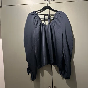 Blus med volanger från 2NDDAY - Svart/gråblå blus ’Liana’ från 2ndday med volanger på ärmarna Oanvänd utan lappar, nytt skick  Storlek 40  90% polyester 2% elastan