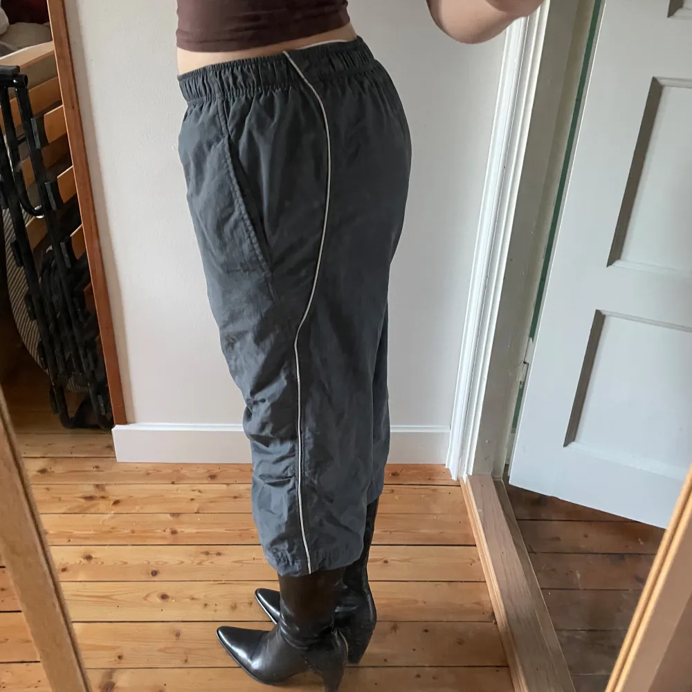 Säljer ett par grå Capris / trekvartsbyxor från Nike i bra skick. De har en loose passform och sitter otroligt bekvämt. Byxorna har en elastisk midja och är tillverkade i ett syntetmaterial som andas bra. Perfekta för höst och vår!. Jeans & Byxor.