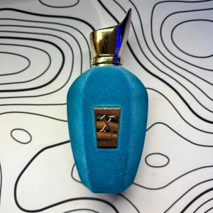 Xerjoff Erba Pura Parfym - Lyxig parfym från Xerjoff i en elegant blå flaska med guldfärgad kork. Förpackningen är stilren med en vit och lila design. Perfekt för den som söker en exklusiv doftupplevelse. Priset är självfallet diskuterbart. 