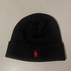 Svart mössa från Ralph Lauren - Snygg svart mössa från Ralph Lauren! Helt ny utan prislapp, aldrig använd 