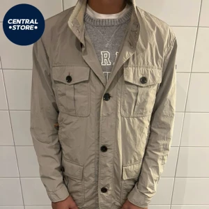 Hackett London Field Jacket - Riktigt fet Hacketg London field jacka med en schysst grå/beige färg. Storlek M & modellen är ca 182 cm lång. Riktigt bra skick inga defekter. Pris 1199kr men går att diskutera vid snabb affär. Tveka inte att kontakta vid andra funderingar // CS