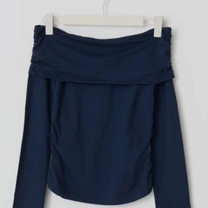 off shoulder top - Långärmad off shoulder topp med rynkningar i sidorna. Toppen är marinblå och har nervikt ovankant. Det står storlek 170 men jag skulle säga att det passar S