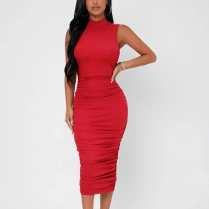  klänning - Helt ny. Snygg röd klänning med hög hals och ärmlös design. Klänningen har en tight passform och når till knäna, vilket ger en elegant siluett. Stretchigt material. Perfekt för en kväll ute eller en speciell tillställning.