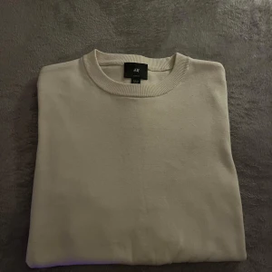 Beige tröja från H&M - Säljer en stilren beige tröja från H&M i slim fit. Perfekt för en minimalistisk look. Tröjan har en rund halsringning och är tillverkad i ett mjukt material.