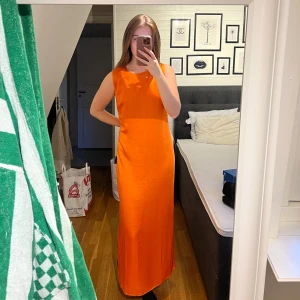 Orange långklänning från Samsøe Samsøe - Snygg orange långklänning från Samsøe Samsøe som är helt oanvänd med alla lappar kvar. Klänningen är ärmlös och har en slits på ena sidan. Storlek XL men passar även mindre beroende på hur man vill att den ska sitta. Nypris 1800 kr!! Så passa på, först till kvarn❤️  