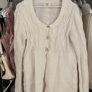 Vit stickad babydoll kofta från L.O.G.G. - Mysig vit stickad babydoll kofta från L.O.G.G. med dekorativa flätmönster och knappar framtill! Öppen för prisförslag!!