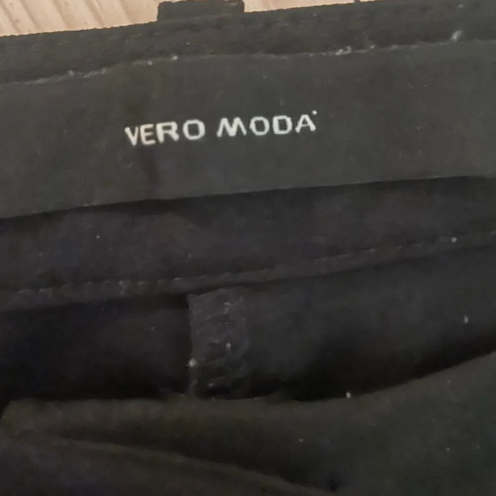 Snygga svarta byxor från Vero Moda. Perfekta för en stilren look. De har en klassisk design med en rak passform och är tillverkade i ett bekvämt material.. Farkut & Housut.