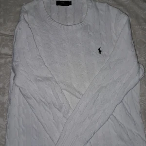 Vit stickad tröja från Ralph Lauren - Säljer en klassisk vit stickad tröja från Ralph Lauren med det ikoniska broderade logotypen på bröstet. Tröjan har en rund halsringning och långa ärmar, perfekt för kyligare dagar. Original pris 2395kr på zalando säljer för 800