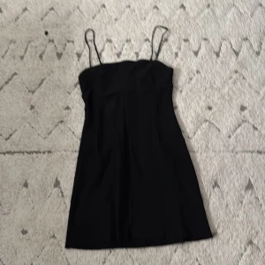 Svart klänning i storlek XS-S som inte är för tajt för mig som bär storlek S - Helt oanvänd och säljer på grund av att den inte har kommit till användning. Vid framsidan och baksidan så har den typ lite korsett vibe + det är inte tunt material utan ganska tjockt