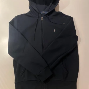 Polo Ralph Lauren zip-up hoodie - Säljer denna snygga Ralph Lauren hoodie i storlek S, tröjan är i väldigt bra skick och känns som ny. Säljer eftersom den är för liten för mig.                     Hör av dig vid frågor!