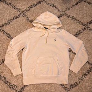 Ralph Lauren Hoodie - Säljer en stilren vit hoodie från Ralph Lauren. Skicket är perfekt då den knappt är använd sedan köpet. Storleken är M.