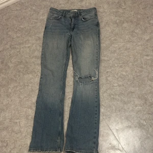 Jeans  - Blåa jeans med hål på ena benet från ginatricot, fint skick! 