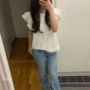 Vit blus med volangärmar - Säljer en söt vit blus med volangärmar och rund hals. Endast använt enstaka gånger!💕Storlek 146-152, men skulle säga att det är XS-S