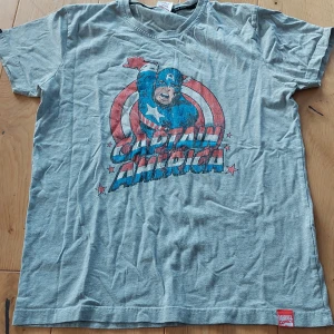 Grå Captain America t-shirt från Jack & Jones - Säljer en grå t-shirt med Captain America-tryck från Jack & Jones.  Buda på💙