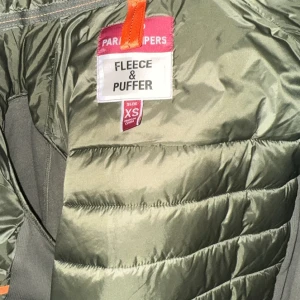 Grön pufferjacka från Parajumpers - Snygg grön pufferjacka från Parajumpers i storlek XS. Jackan har en dragkedja framtill och en mysig huva. Perfekt för kyliga dagar med sin quiltade design och fleecefoder.