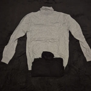 Grå och svart polotröja - Säljer två stilrena grå och svart polotröja med långa ärmar. Perfekt för kyligare dagar och enkel att matcha med olika outfits.